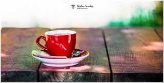 Dieses Foto ist als kostenloser Download (ohne Rand und Signatur) im Originalformat oder als Print zum Kauf/Mieten in meinem Shop auf <a href="https://butlaix.de/produkt/foto-rote-tasse-no-2-als-leinwand-alu-dibond/" target="_blank" rel="noreferrer noopener" >BUTLAIX_media</a> verfügbar. Eine rote Kaffeetasse auf Untertasse mit Löffel und Zuckerstückchen steht auf einem rustikalen Holztisch; der Hintergrund ist hell und unscharf, mit grünlichen Farbflecken und Sonnenlicht.