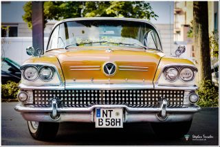 Dieses Foto ist als kostenloser Download (ohne Rand und Signatur) im Originalformat oder als Print zum Kauf/Mieten in meinem Shop auf <a href="https://butlaix.de/produkt/fotografie-oldtimer-no-3/" target="_blank" rel="noreferrer noopener" >BUTLAIX_media</a> verfügbar. Frontansicht eines goldgelben Buick Oldtimers ca. 1958 mit charakteristischem Chromgrill, Doppelscheinwerfern, Buick-Schriftzug und deutschem Kennzeichen NT-B 58H. Weißwandreifen sichtbar.