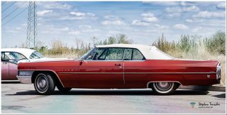Dieses Foto ist als kostenloser Download (ohne Rand und Signatur) im Originalformat oder als Print zum Kauf/Mieten in meinem Shop auf <a href="https://butlaix.de/produkt/fotografie-oldtimer-no-14/" target="_blank" rel="noreferrer noopener" >BUTLAIX_media</a> verfügbar. Roter Cadillac DeVille Cabriolet mit weißem Verdeck aus den 1960er Jahren, Seitenansicht, geparkt auf einem Platz vor Büschen und bewölktem Himmel. Links teilweise ein weiteres Vintage-Auto sichtbar.